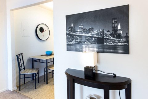 a living room with a table and a clock on the wall